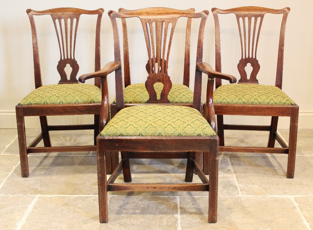 A set of seven George III mahogany Hepplewhite style dining chairs, each chair with a pierced