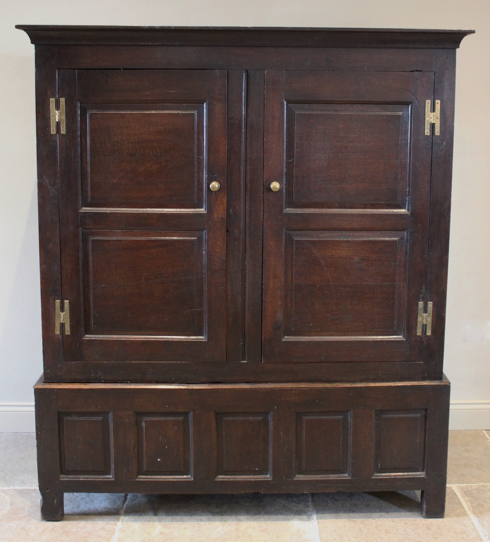 An 18th century oak livery cupboard, the cavetto cornice above a pair of panelled cupboard doors,