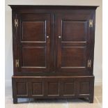 An 18th century oak livery cupboard, the cavetto cornice above a pair of panelled cupboard doors,