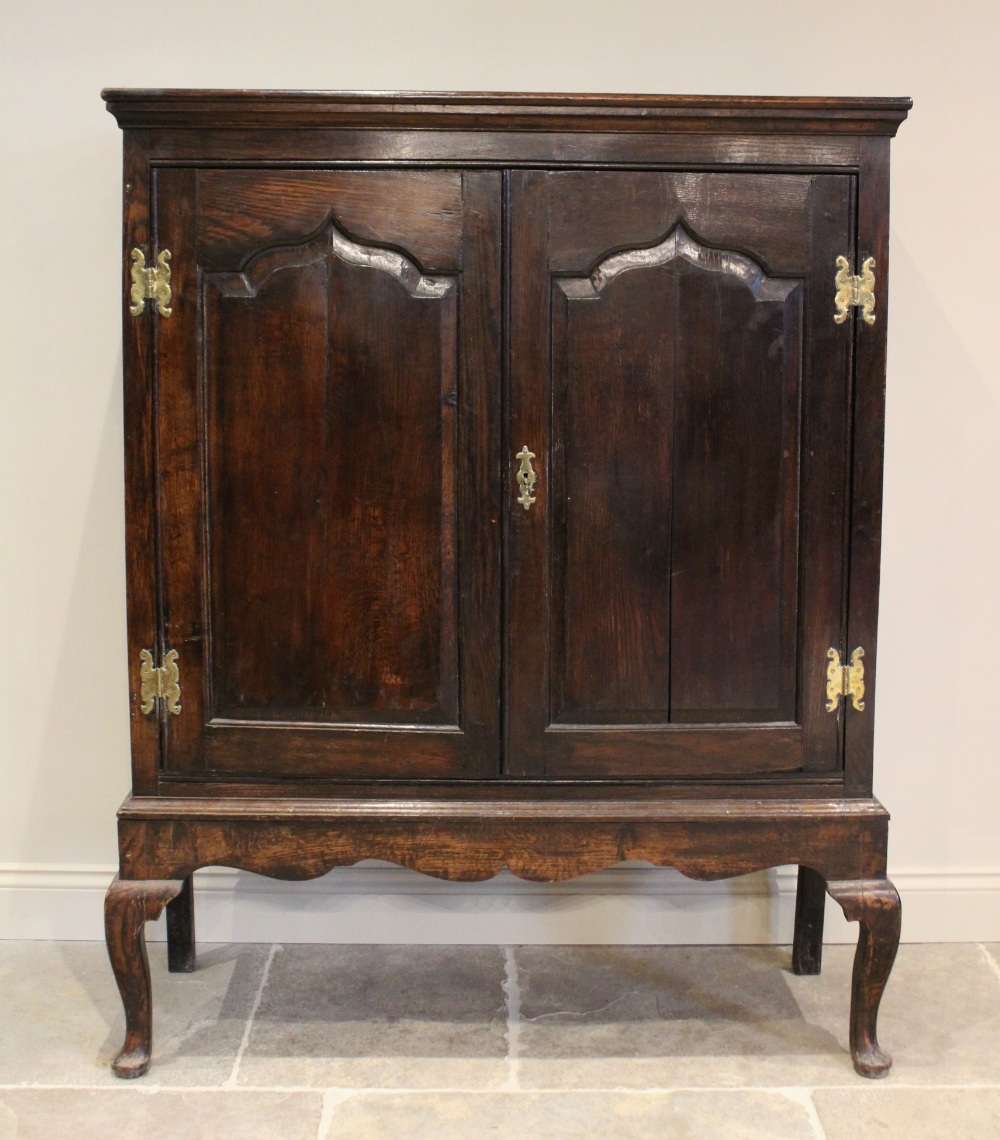 A mid 18th century and later oak cabinet on stand, the moulded cornice above two fielded panel doors - Image 2 of 4