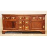 A mid 18th century fruitwood dresser base, the rectangular moulded top above three central invert