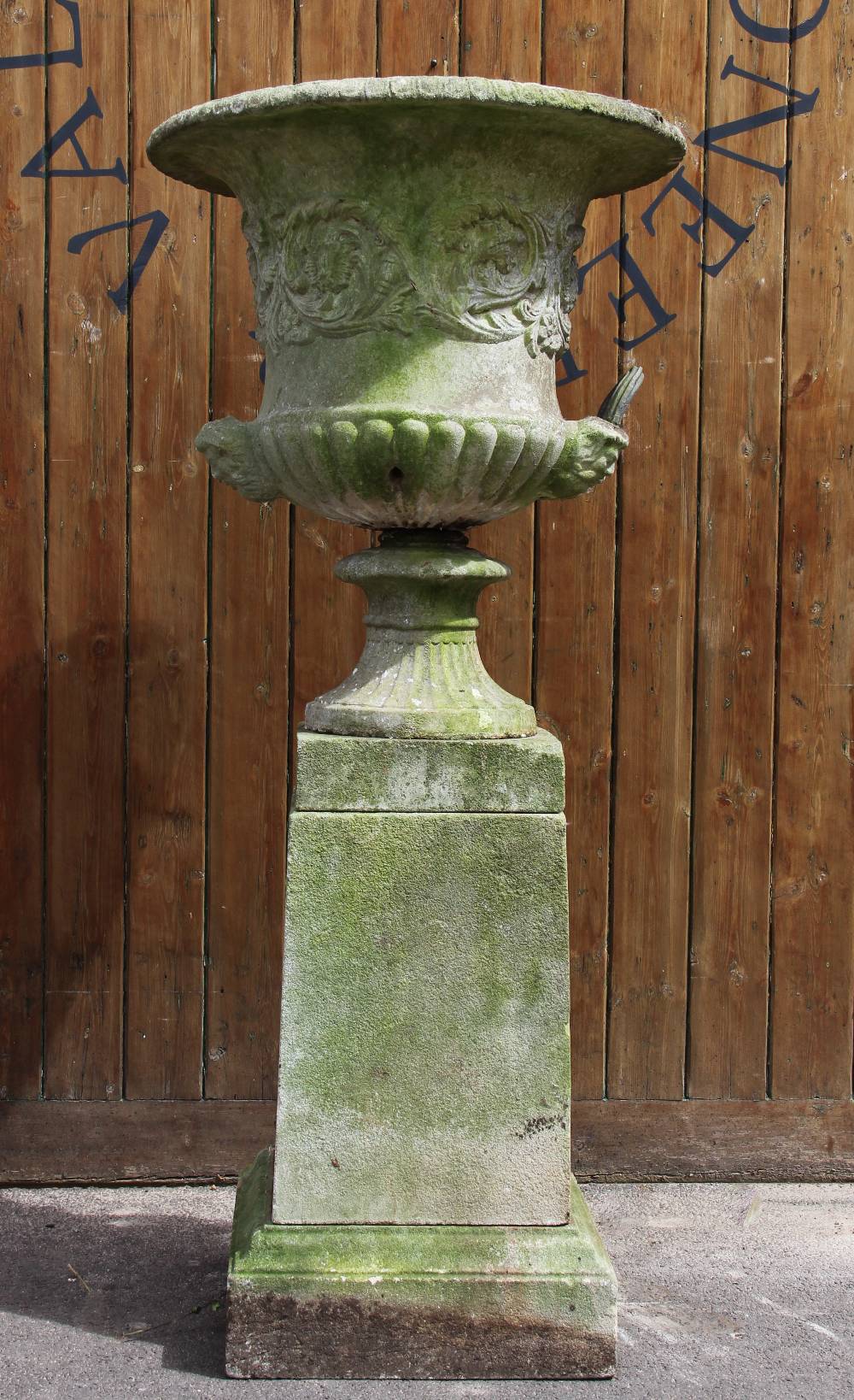 A reconstituted stone campana garden urn, of typical lobed form, moulded in relief with scrolling