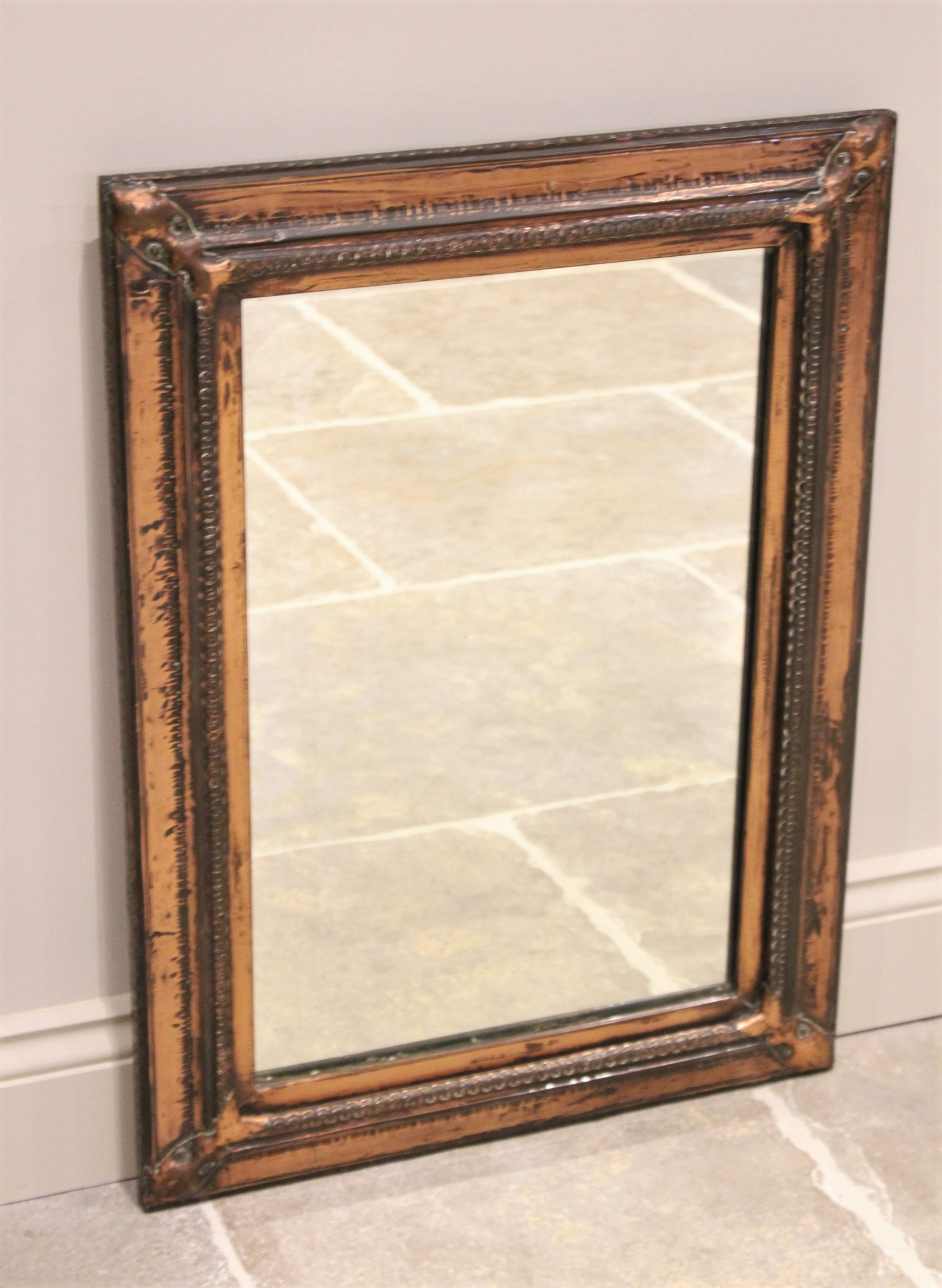 An early 20th century Arts and Crafts copper wall mirror,