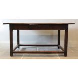 An early 18th century oak kitchen table, the cleated plank top raised upon chamfered legs of square,