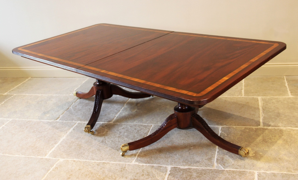 A Regency style twin pillar mahogany dining table, late 20th century, the rectangular satinwood