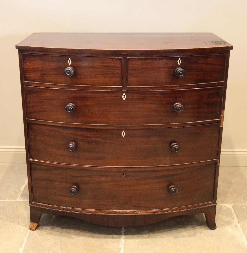 An early 19th century mahogany bow front chest of drawers, with an arrangement of two short over