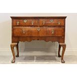 An early 18th century figured walnut side table/low boy, the quarter veneered and cross banded