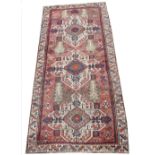 A large Turkish wool runner, with three geometric medallions upon a red ground, within a