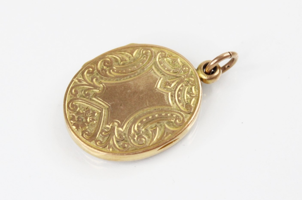 A George V 9ct gold locket pendant, of oval form, engraved with scrolling and foliate decoration,