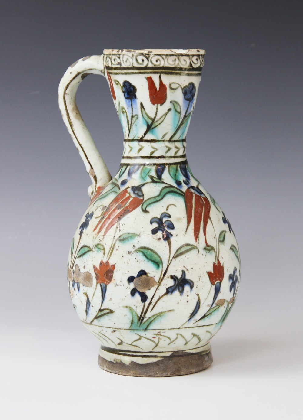 An Ottoman Empire Turkish polychrome pottery jug, of pear shape with attached handle and flared