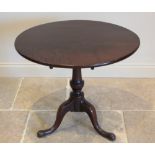 A George III mahogany tripod table, the circular tilt top raised upon a ring turned baluster