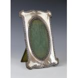 An Edwardian silver mounted photograph frame by Charles S Green & Co Ltd, Birmingham 1906, of shaped