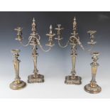 A pair of early 20th century silver plated three-branch candelabras, each on shaped square bases and