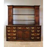 A mid 18th century oak Welsh dresser, the inverted breakfront dresser rack with a moulded cornice