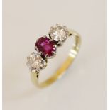 An 18ct gold pink sapphire and diamond three-stone ring, comprising a central oval mixed cut pink
