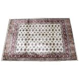 An ivory ground full pile Kashmir carpet, with an all over Bokhara design, 240cm x 160cm