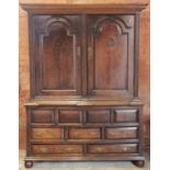 An early 18th century oak livery cupboard, the moulded cornice above a pair of fielded panelled