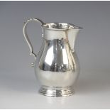 A George VI silver milk jug by Blackmore & Fletcher Ltd, London 1938, of baluster form on stepped