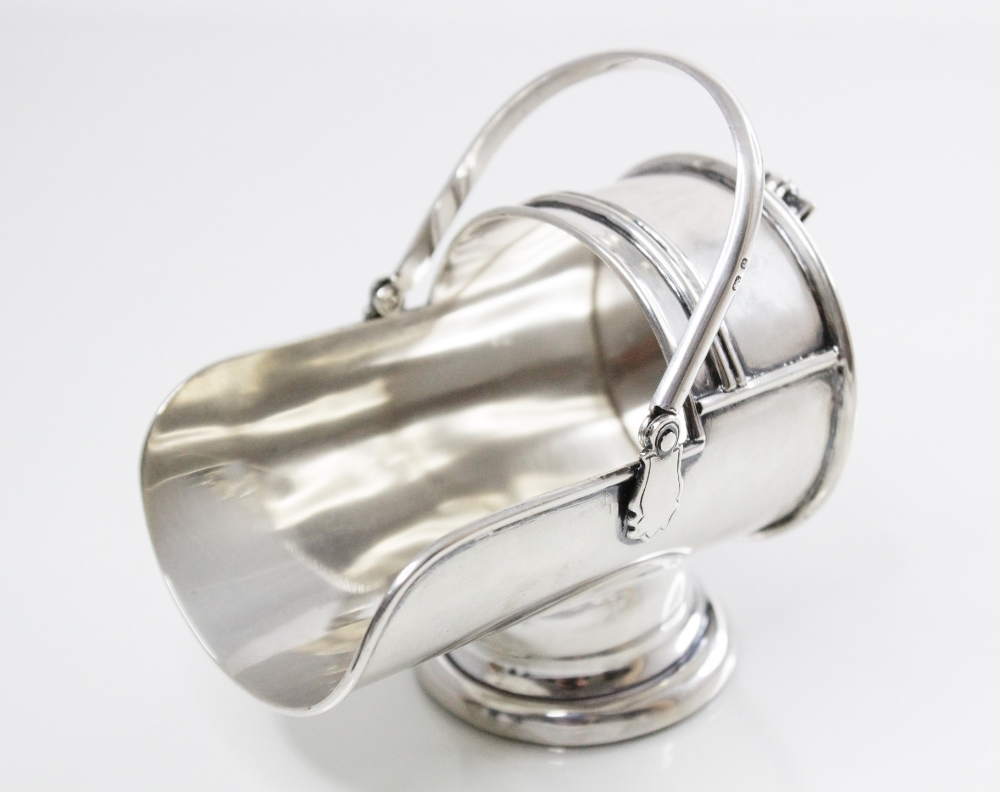 A silver model of a coal scuttle by Williams Ltd, Birmingham 1904, with swing handle on a pedestal