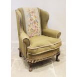 A George II style wing back fireside armchair, early 20th century, the padded wing backs extending