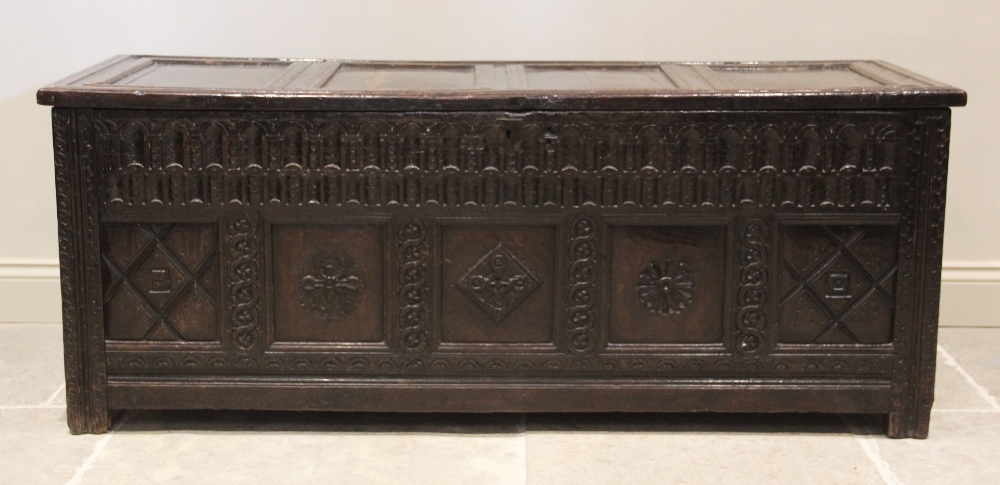 A 17th century oak coffer, the hinged cover with four invert moulded panels above a double nulled