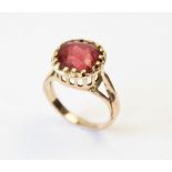 A tourmaline ring, the central orange-pink cushion cut tourmaline (measuring 8.8mm x 8.9mm), claw