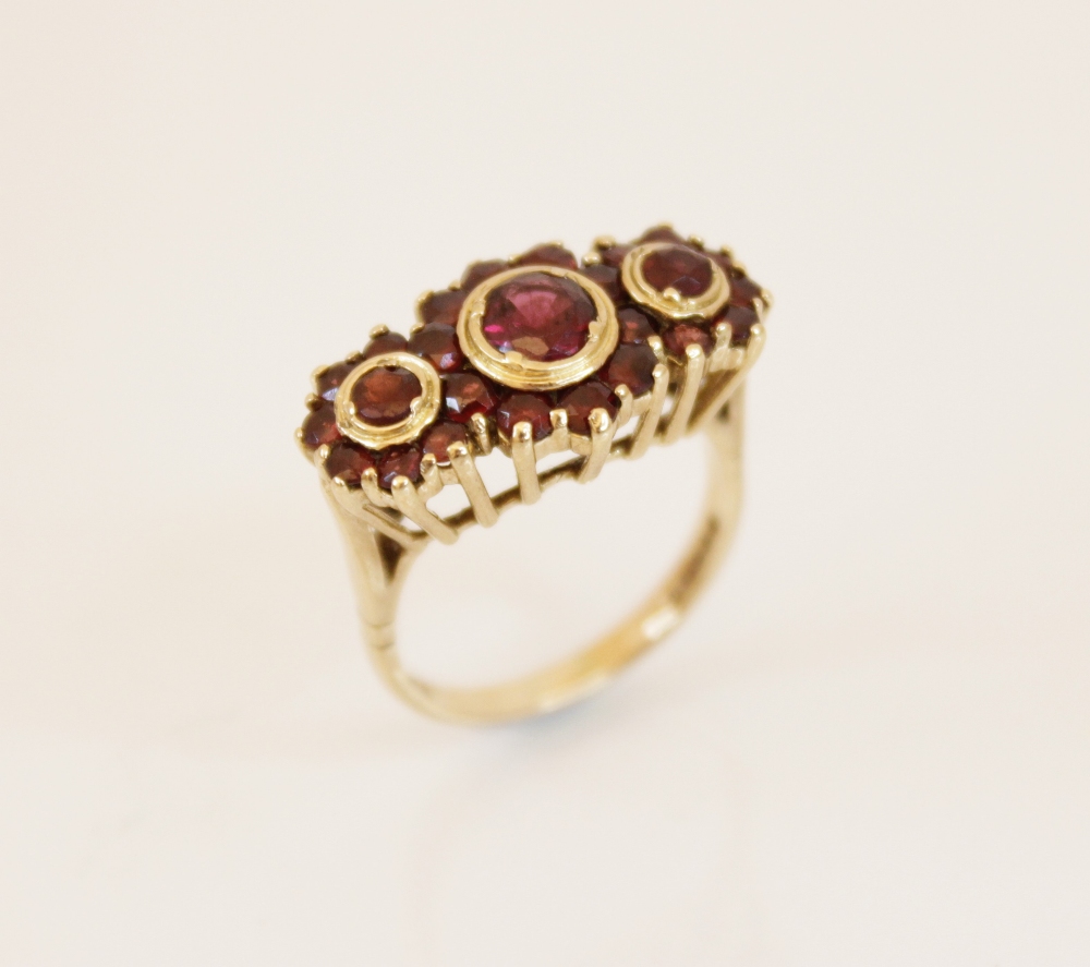 A 9ct gold garnet cluster ring, comprising three principle round mixed cut garnets (measuring