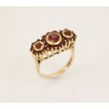 A 9ct gold garnet cluster ring, comprising three principle round mixed cut garnets (measuring