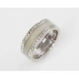 A jade and diamond 18ct white gold ring, the central channel set with polished jade, flanked by