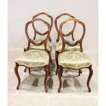 A set of six Victorian walnut dining chairs, each with a leaf swept balloon back above a stuff