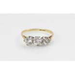 A diamond three stone ring, comprising a central round brilliant cut diamond (weighing approximately