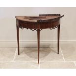 An early 19th century mahogany demi lune hall table, the bow front top with roundel and string inlay