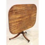 An early 19th century mahogany pedestal table, the rectangular tilt top with rounded corners, raised