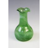 A 'Clutha' style green bubbled glass vase in the manner of Christopher Dresser for James Coupar &