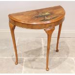 An early 20th century Japanned walnut demi lune hall table, the table top applied in gilt relief