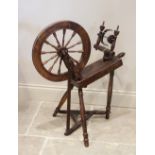 An early 20th century oak spinning wheel, extensively carved and dated 1902, 88cm x 80cm