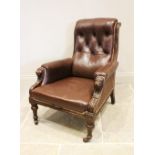 A Victorian walnut and leather library armchair, the curved button back flanked by channelled