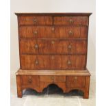 An early 18th century figured walnut chest on stand, the over hanging rectangular top above two