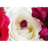 A ruby and diamond cluster ring, the central rectangular cushion cut ruby (measuring 8.2 x 6.6 x 4.