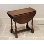A Mouseman style oak table, early 20th century, the oval drop leaf top raised upon ring turned