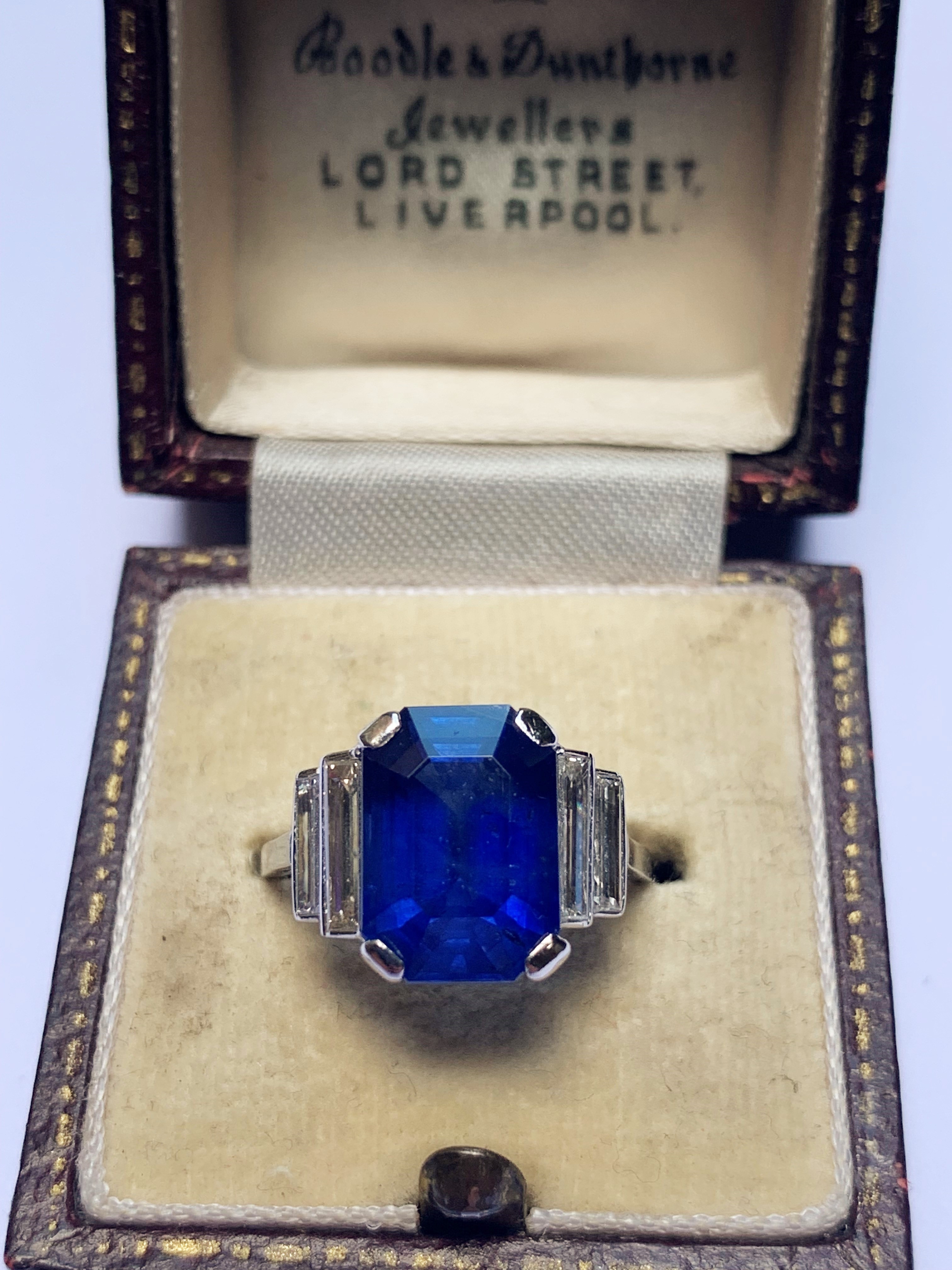 An Art Deco sapphire and diamond ring, the central octagonal step cut sapphire (measuring 11.79mm