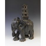 An early 20th century ebony carving of an elephant, modelled with a pagoda upon its back, 58cm high,