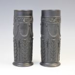 A pair of Wedgwood black basalt cylinder vases, early 20th century, the bodies extensively decorated