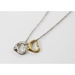 A Tiffany & Co Elsa Peretti 18ct gold open heart pendant, 11mm wide, together with a silver example,