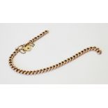 A yellow metal curb link bracelet, 21.5cm long, suspending a 9ct gold heart-shaped padlock fastener,
