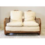 A 1930's Art Deco walnut three piece bergere suite, the two seater settee with a twin oval rattan