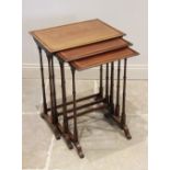An Edwardian nest of three mahogany and satinwood cross banded tea tables, upon slender ring
