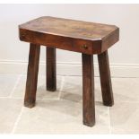 An early 20th century elm butchers block type table, the rectangular slab top with canted corners,