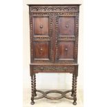 A 17th century style oak cabinet on stand, circa 1930, the lunette carved frieze above twin panelled