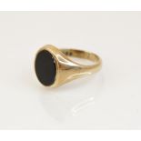 A 9ct gold black onyx signet ring, the oval onyx panel measuring 12mm x 10mm, set in 9ct yellow gold